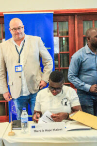 TIH Executive Director, Cathreen Ndege-Chirwa officially signs for the equipment and items